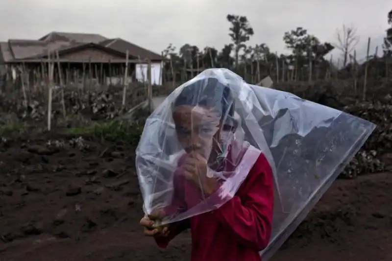 Il ragazzino di Sumatra si copre per non respirare la cenere del vulcano 