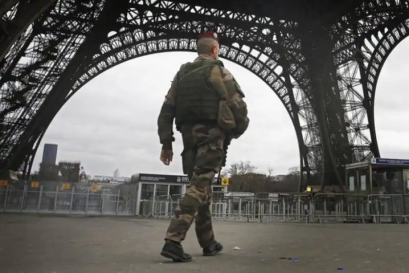 Un soldato sotto la torre Eiffel a Parigi 