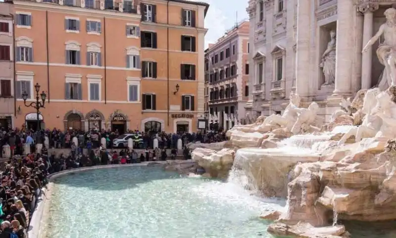 turisti seduti alla fontana di trevi