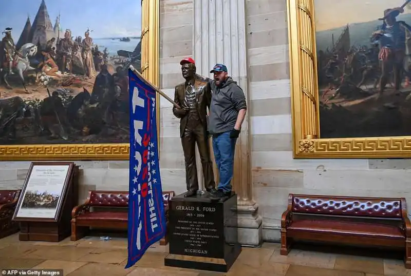 supporter di trump si fa una foto con la statua di gerald ford 