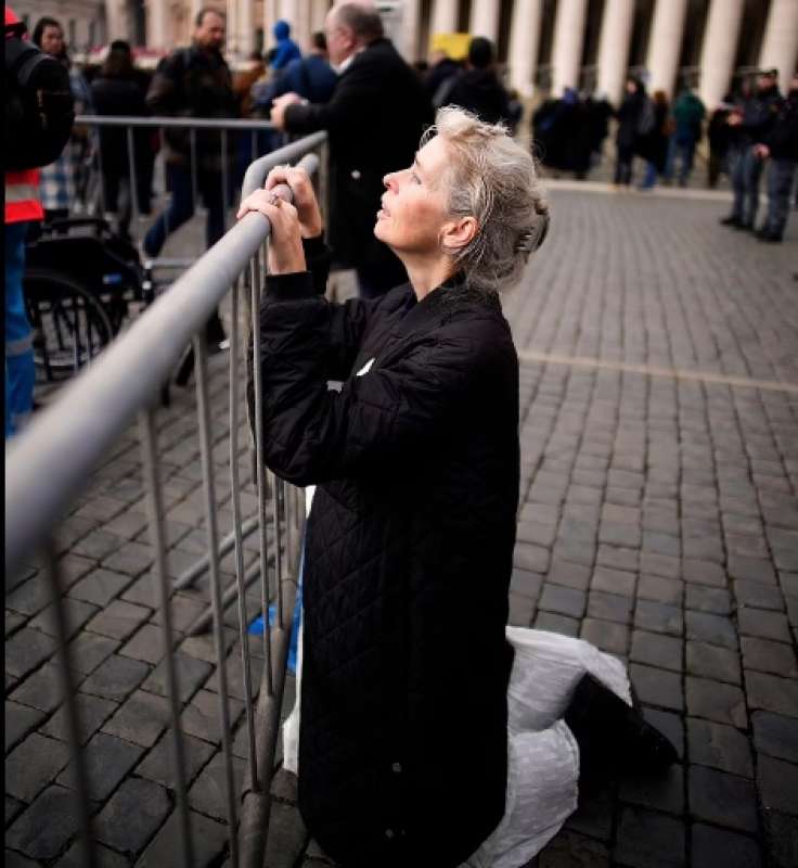 donna in ginocchio ai funerali di ratzinger