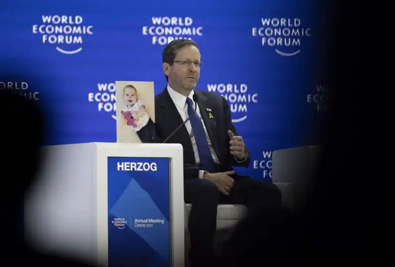 ISAAC HERZOG CON LA FOTO DEL PICCOLO KFIR BIBAS A DAVOS 