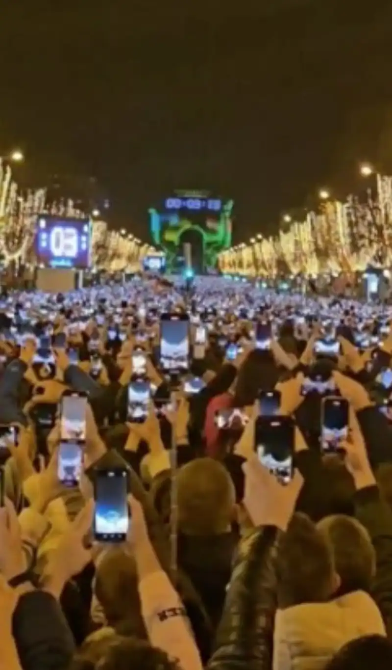 marea di telefonini a mezzanotte sugli champs elysees a parigi 1