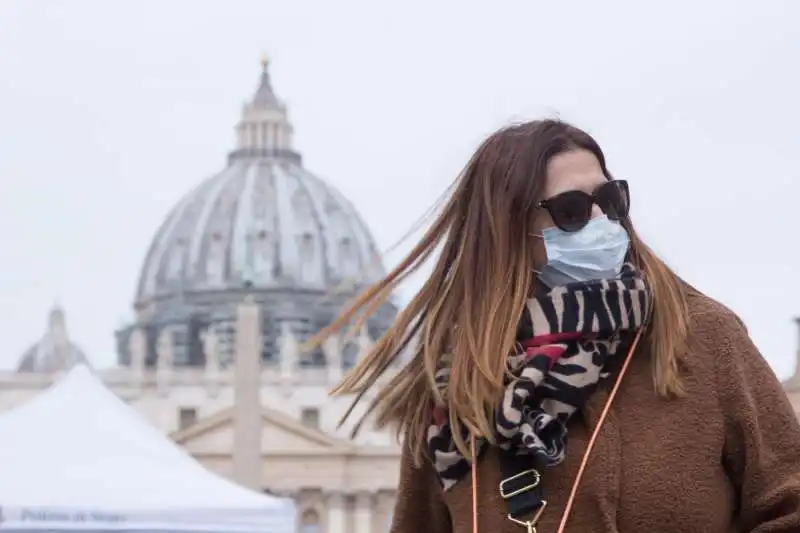 turista con la mascherina a san pietro