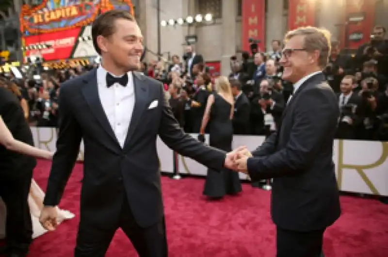 wolf of wall street best actor nominee leonardo dicaprio embraces christoph waltz on the red carpet 