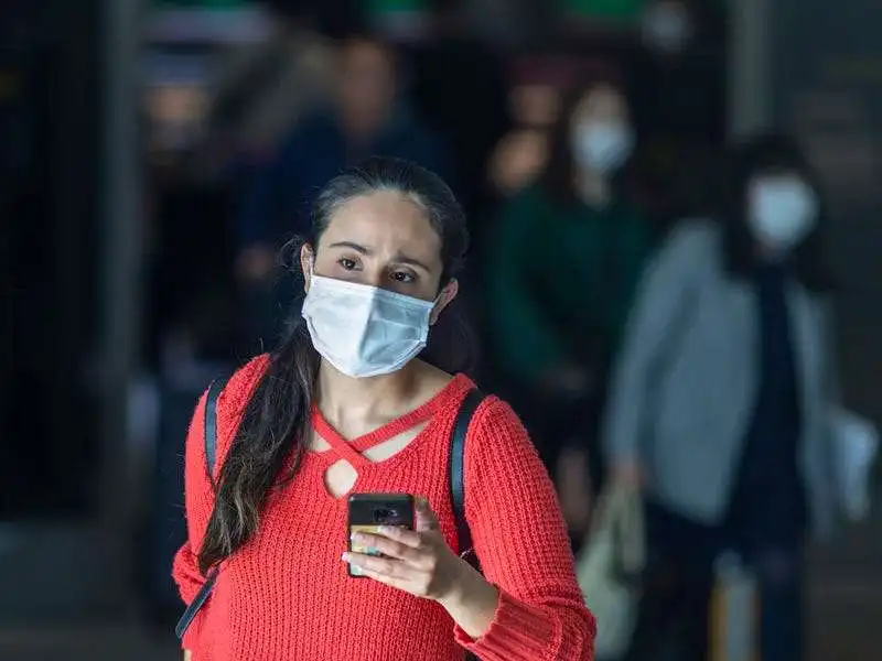 una viaggiatrice indossa una mascherina sanitaria al los angeles internation airport