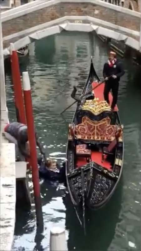 venezia, donna salta sulla gondola