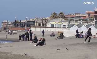 ostia, gente in spiaggia e sul lungomare domenica delle palme