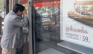 un uomo guarda dentro a un mcdonald's chiuso in russia