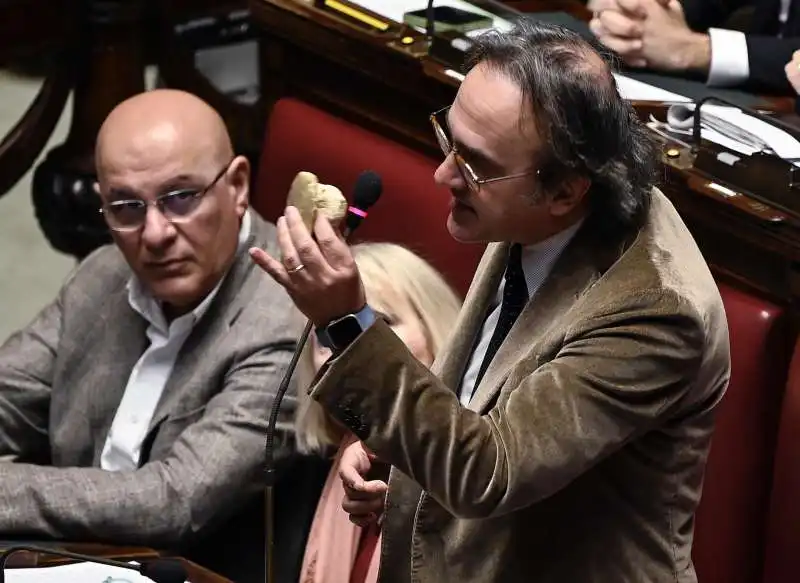 ANGELO BONELLI CON DUE SASSI ALLA CAMERA  