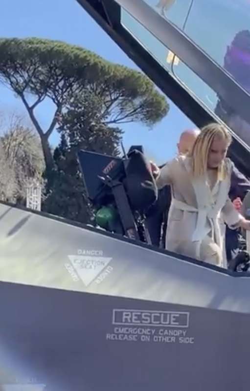 giorgia meloni dentro un aereo da combattimento a piazza del popolo