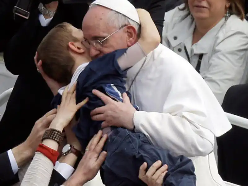 papa francesco bergoglio prende in braccio un bimbo disabile a pasqua 