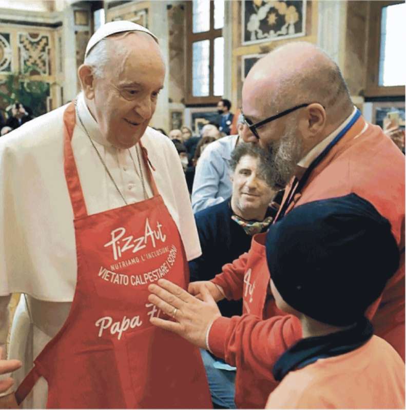 il papa col grembiule della pizza fatta dai ragazzi autistici