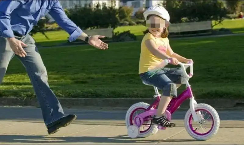 padre insegna alla figlia ad andare in bicicletta senza rotelle