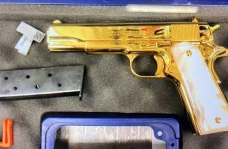 pistola placcata d'oro nella valigia