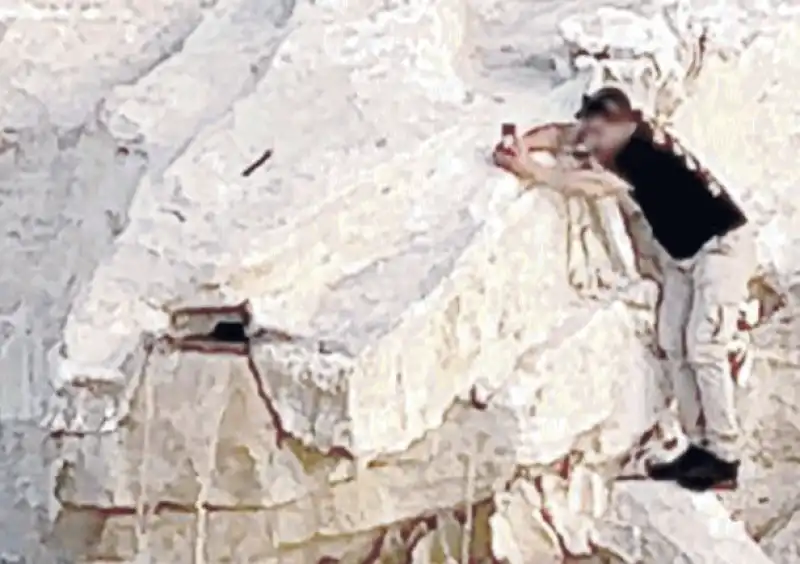 turista si arrampica sulla fontana di trevi per farsi un selfie