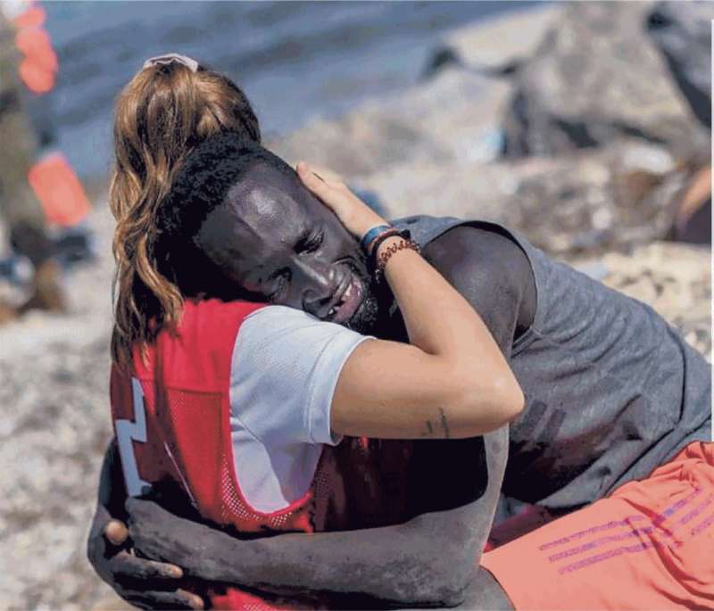 LA STAGISTA DELLA CROCE ROSSA LUNA REYES ABBRACCIA UN MIGRANTE SENEGALESE A CEUTA