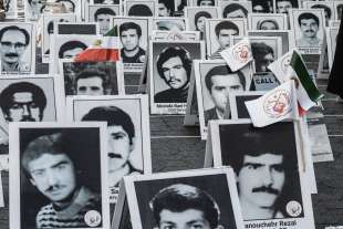 le foto delle vittime del massacro del 1988 in iran, mostrate durante una protesta contro raisi a new york nel 2022