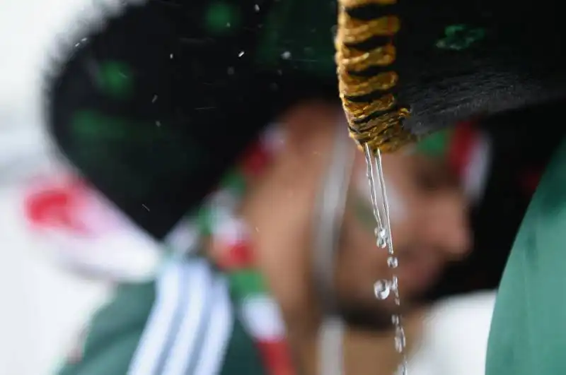 la pioggia scende dal cappello di un tifoso durante la partita messico camerun