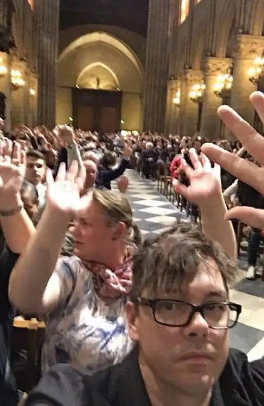 turisti bloccati a notre dame con le mani alzate