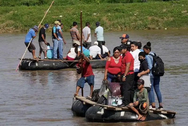 migranti attraversano il fiume suchiate in messico 