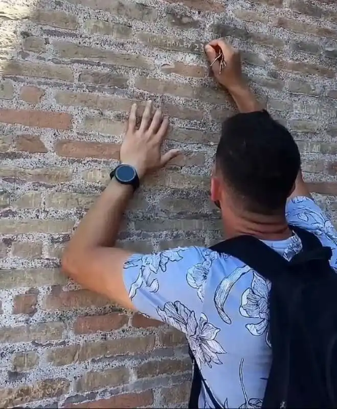 turista scrive il nome della fidanzata sul muro del colosseo