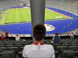 tifoso seduto dietro a un palo allo stadio olimpico di berlino