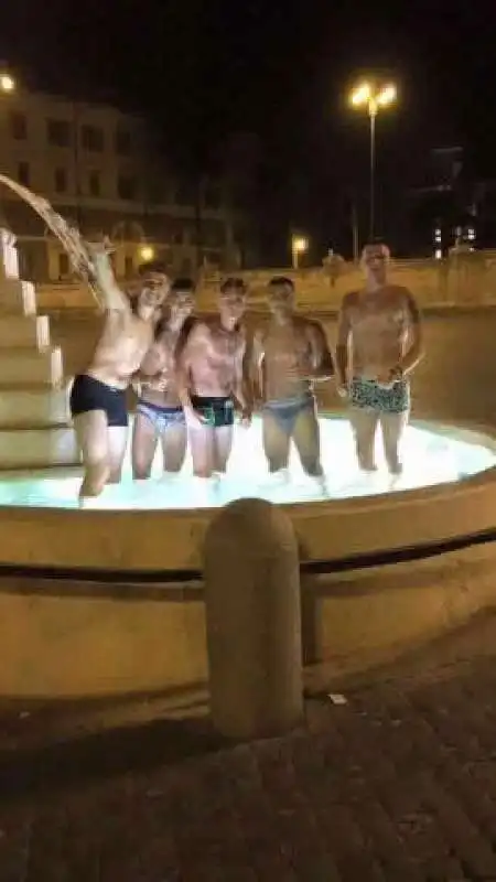 un gruppo di romani fa il bagno alla fontana dei leoni piazza del popolo  