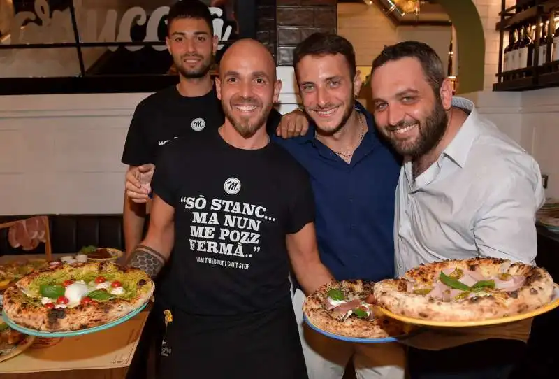 lo staff del mariuccia con le pizze  foto di bacco