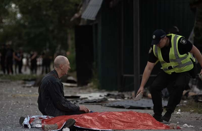 uomo disperato accanto al corpo del figlio a kharkiv