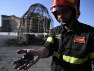 un vigile del fuoco di fronte alla venere degli specchi bruciata da un clochard