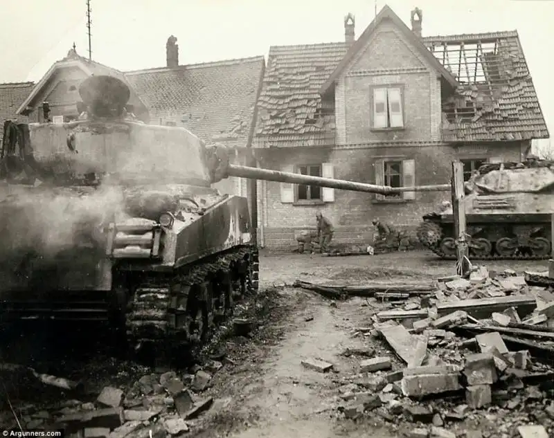 carro armato americano di muove tra le rovine di una cittadina francese