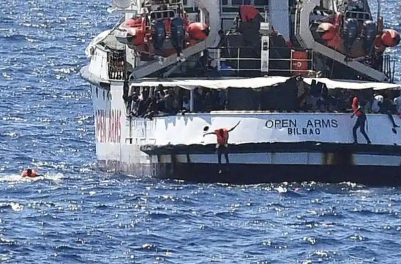 migranti si tuffano dalla open arms 1