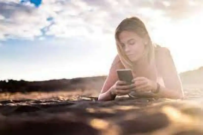 in spiaggia  con il cellualre