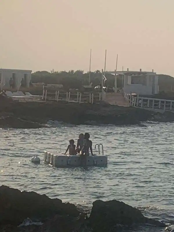 madonna con i figli fa il bagno sulla pedana della spiaggia di borgo egnazia 1