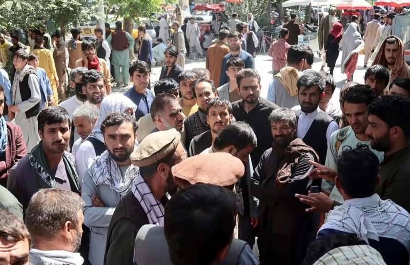 persone in fila davanti alle banche a kabul