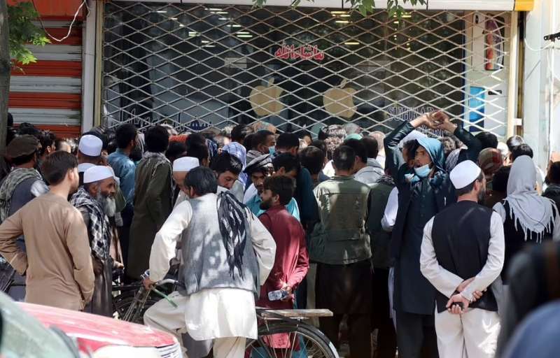 persone in fila davanti alle banche a kabul