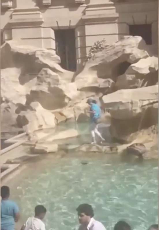 turista riempie la bottiglia d acqua nella fontana di trevi