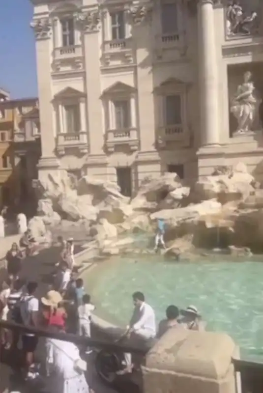 turista riempie la bottiglia d acqua nella fontana di trevi 2