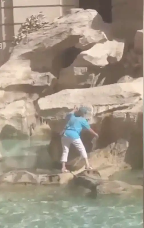 turista riempie la bottiglia d acqua nella fontana di trevi 5