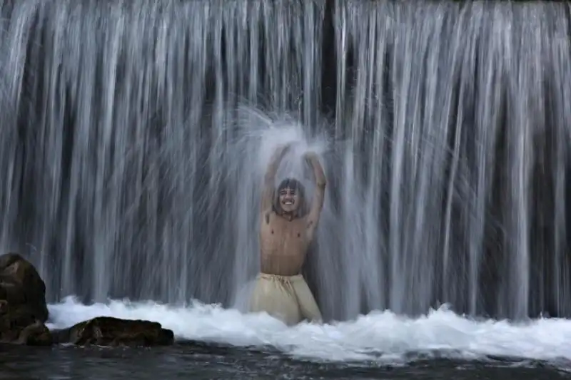 RAGAZZO PACHISTANO SOTTO UNA CASCATA A ISLAMABAD 