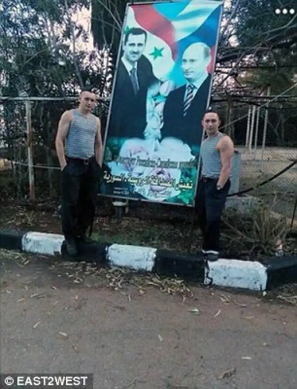 militari russi posano con foto di putin e assad