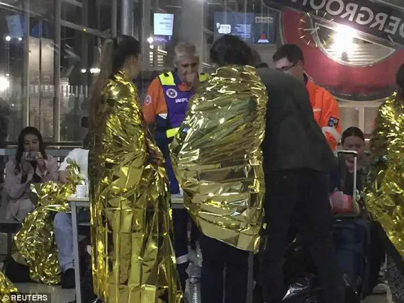 passeggeri con coperte termiche alla stazione di calais