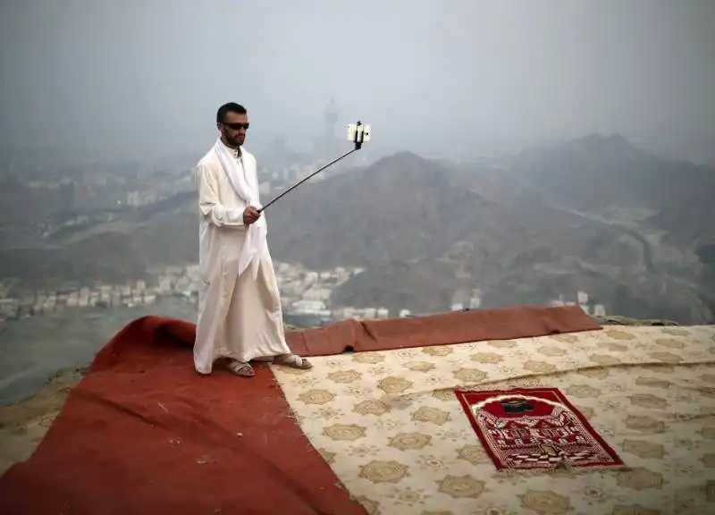 pellegrino musulmano si fa un selfie davanti alla mecca