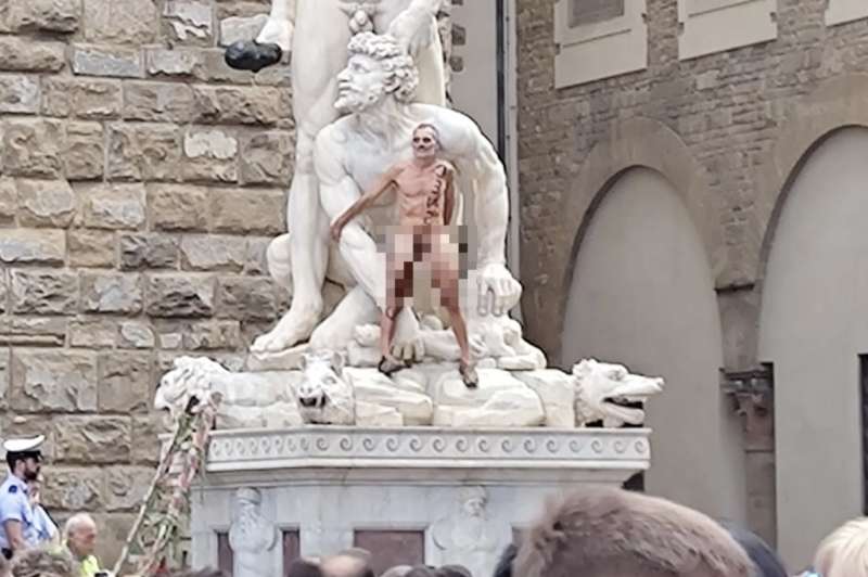 FIRENZE - UN UOMO NUDO SALE SU UNA STATUA A PIAZZA DELLA SIGNORIA