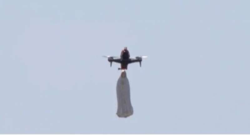 nel cielo sopra trevignano la statua della madonna appesa a un drone