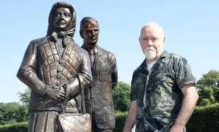 anto brennan con la statua della regina elisabetta e il principe filippo in irlanda del nord