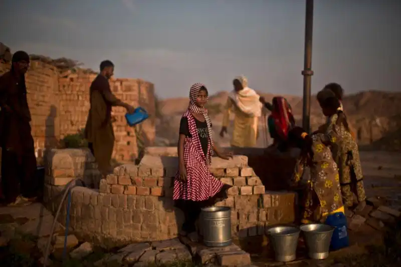 Una donna pachistana si rifornisce di acqua presso una fonte a Islamabad in Pakistan 