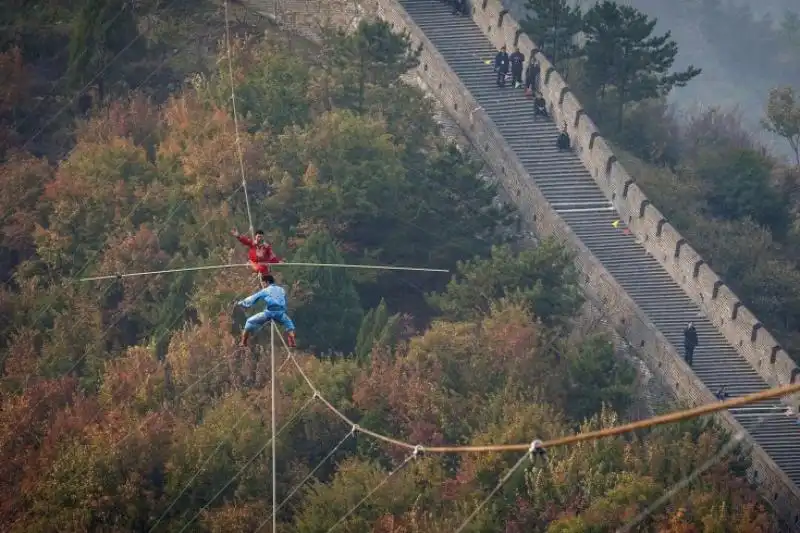 Due funamboli si esercitano sulla Grande Muraglia a Tianjin in Cina 