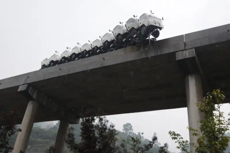 Un treno che trasporta camion in bilico su un ponte a Kaili in Cina 